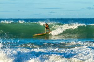 un homme qui fait du paddle dans les vagues