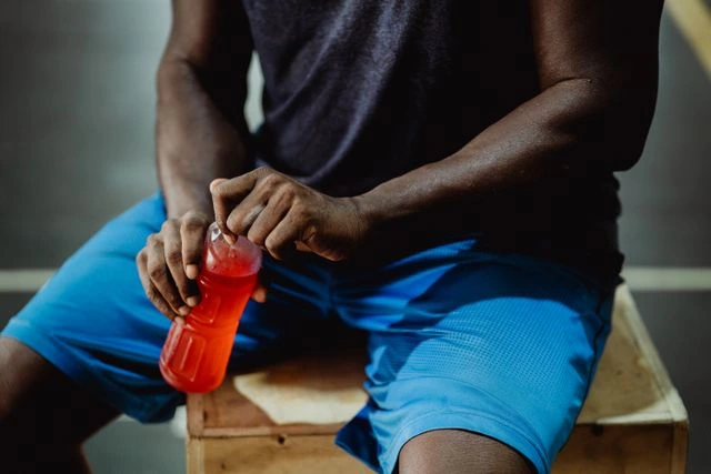 un sportif qui boit une boisson énergétique