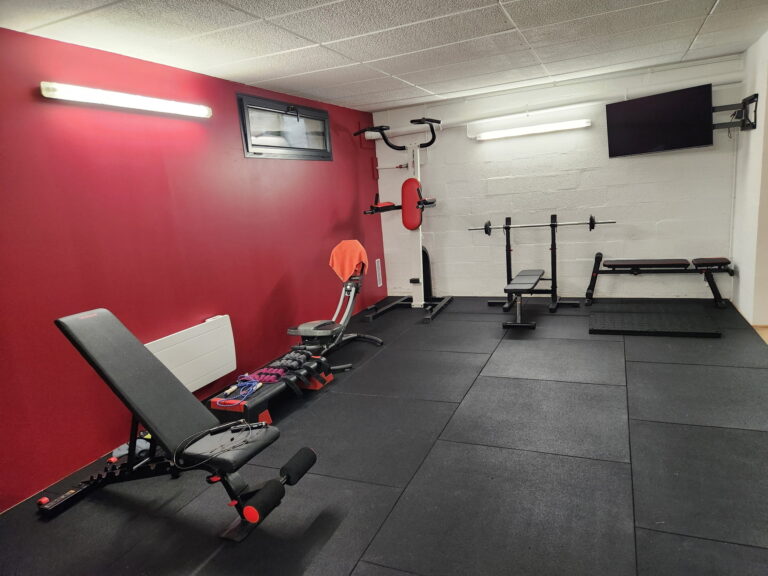 une salle de crossfit avec un mur rouge